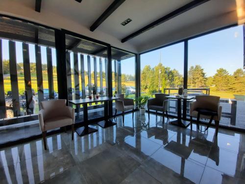 comedor con mesa, sillas y ventanas grandes en Heba en Divčibare