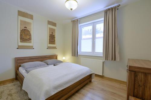 ein Schlafzimmer mit einem großen Bett und einem Fenster in der Unterkunft Apartament u Jacentego in Szklarska Poręba