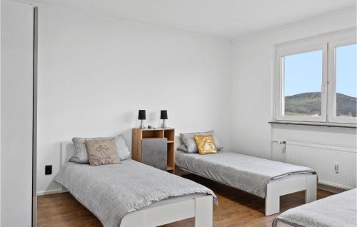 Cette chambre blanche dispose de deux lits et d'une fenêtre. dans l'établissement Lovely Apartment In Tauberbischofsheim With Kitchen, à Tauberbischofsheim