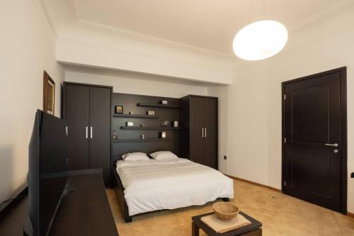 een slaapkamer met een wit bed en een zwarte kast bij Belgrade Center Apartment Lux V in Belgrado