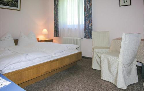 ヴァークラインにあるAwesome Apartment In Wagrain With 2 Bedroomsのベッドと椅子付きのホテルルーム