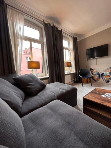 a living room with a couch and a window at Moderner Altbaucharme in zentraler Lage in Kiel