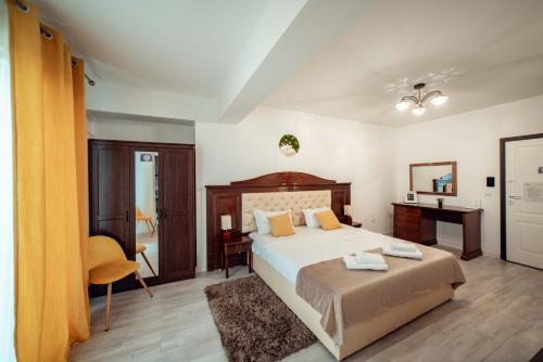 1 dormitorio con 1 cama grande y escritorio en Bright and Cozy Studios and Flats - Palas Mall, en Iaşi