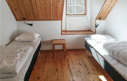 duas camas num quarto com uma mesa e uma janela em Beautiful Home In Kpingsvik With Sauna, Wifi And Indoor Swimming Pool em Grönskog