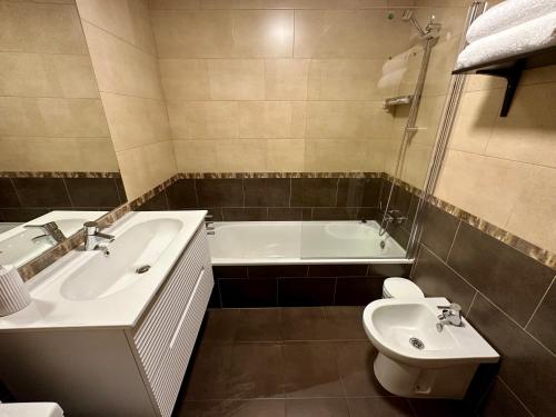 a bathroom with a tub and a toilet and a sink at Apartamento Punto24 con acceso a Parking in Cáceres