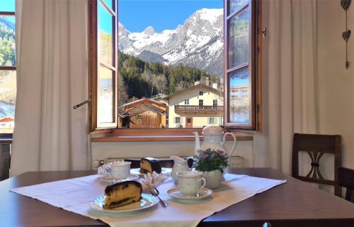 a table with a piece of cake and a view of a mountain at Ferienwohnung im Gästehaus Sieger-Brandner in Ramsau