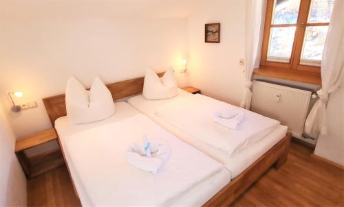 een slaapkamer met 2 bedden en witte kussens bij Ferienwohnung im Gästehaus Sieger-Brandner in Ramsau
