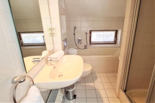 een badkamer met een wastafel, een toilet en een douche bij Ferienwohnung im Gästehaus Sieger-Brandner in Ramsau