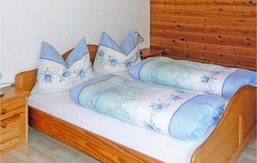 a bed with blue and white sheets and pillows at Große Ferienwohnung Grossarl in Grossarl