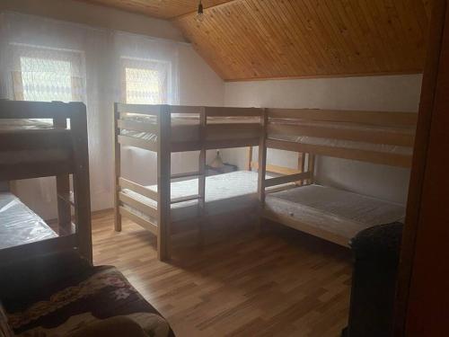 a room with three bunk beds in a house at Vejtse House 