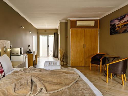 a bedroom with a bed with a blanket on it at Kuruman Lodge in Kuruman