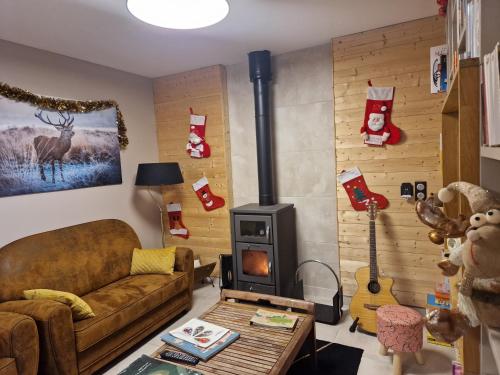 a living room with a couch and a stove at Le jardin des 4 saisons in Le Mans
