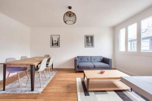 un salon avec une table et un canapé bleu dans l'établissement Merville, charmant appartement proche centre-ville, à Lorient