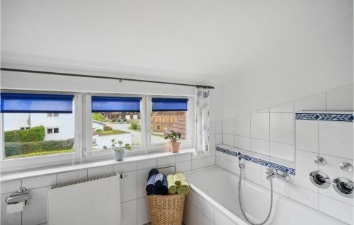 uma casa de banho branca com um chuveiro e uma janela em Stunning Apartment In Hergatz With House A Panoramic View em Hergatz