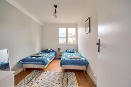 une chambre avec deux lits et une fenêtre dans l'établissement Merville, charmant appartement proche centre-ville, à Lorient