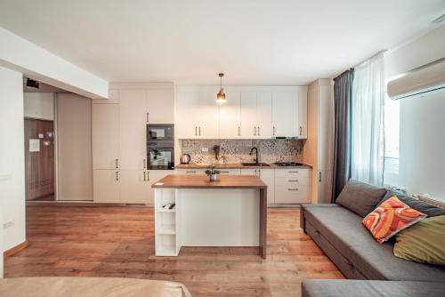 a kitchen and living room with a couch and a table at Bright and Cozy Studios and Flats - Palas Mall in Iaşi