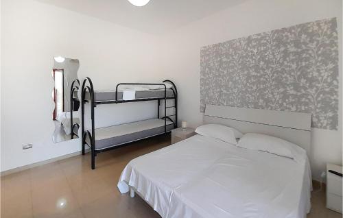 um quarto com uma cama com lençóis brancos e uma parede em Lovely Apartment In Rotondella With Kitchen em Rotondella