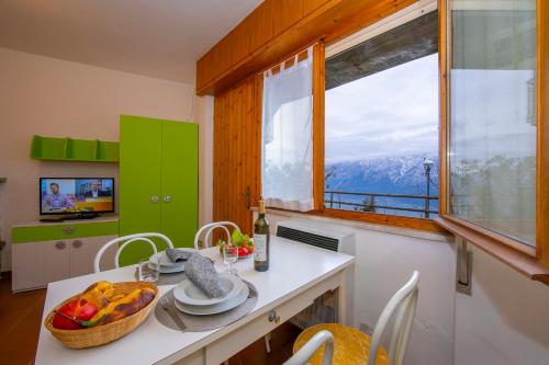 a kitchen with a table with a bowl of fruit and a window at Appartamenti Secrel in Tremosine Sul Garda