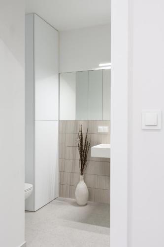 a bathroom with a sink and a vase with a plant at Apartament Redłowska Kępa nad Morzem in Gdynia