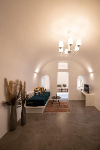 a bedroom with a bed and a chandelier at Belantza Cave House with jacuzzi in Vóthon
