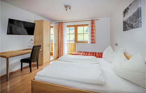 グロースアルルにあるNice Home In Grossarl With 4 Bedrooms And Wifiのベッド2台とデスクが備わるホテルルームです。