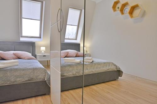 1 Schlafzimmer mit 2 Betten und einem Spiegel in der Unterkunft Apartamenty Bryza - Debina in Świnoujście