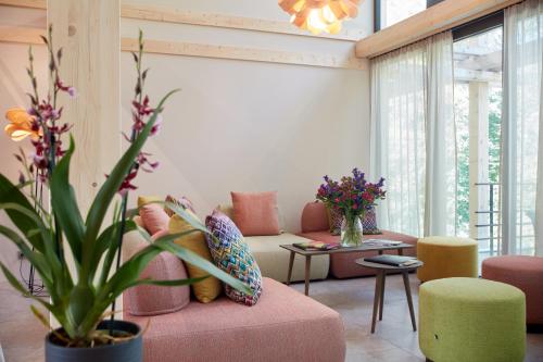 a living room with a pink couch and a plant at Hotel BERGEBLICK in Bad Tölz