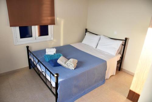 - une chambre avec un lit et des serviettes dans l'établissement Andros Country Residence, à Makrotándalon