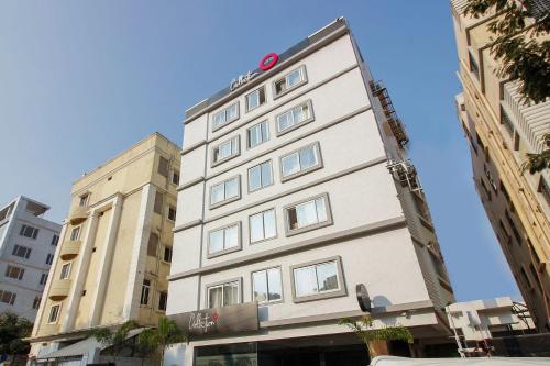 a tall white building with a sign on it at Townhouse Halcyon Hi-Tech City Near Medicover Hospital in Kondapur