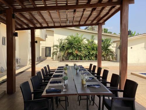 a long wooden table with chairs in a patio at Adis Hotels Prime in Ibadan