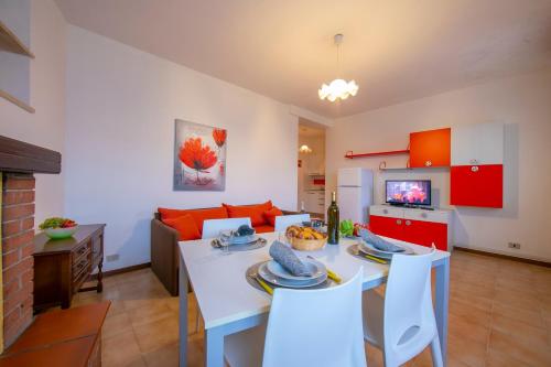 a kitchen and living room with a white table and chairs at Appartamenti Secrel in Tremosine Sul Garda