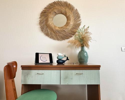 a dressing table with a mirror and a vase with a clock at Villa MG Hotel in Santa Marinella