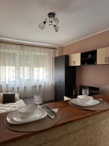 - une table à manger avec des assiettes au-dessus dans l'établissement Cozy Apartament, à Galaţi
