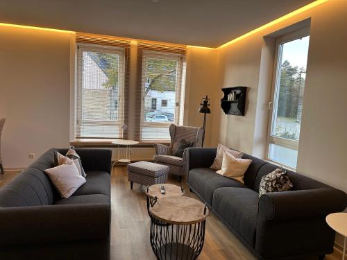 a living room with two couches and a table at Café Ilse - Ferienwohnungen in Ranis