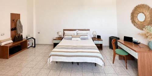 a bedroom with a large bed and a desk at Villa MG Hotel in Santa Marinella
