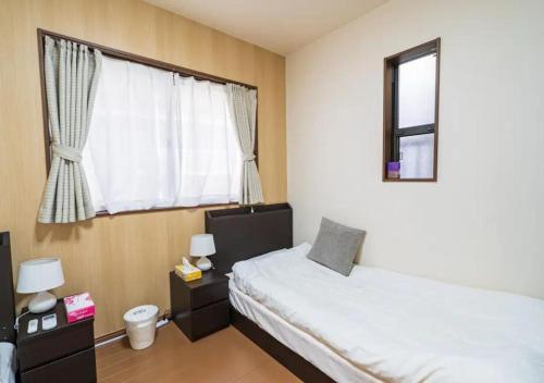 - une petite chambre avec un lit et une fenêtre dans l'établissement Kaya no Kochiku, à Kyoto