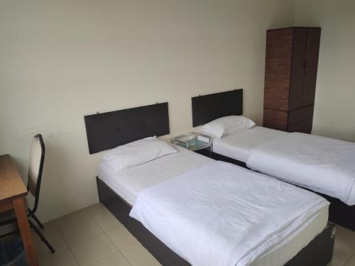 Un pat sau paturi într-o cameră la MELINTANG HOTEL SDN BHD