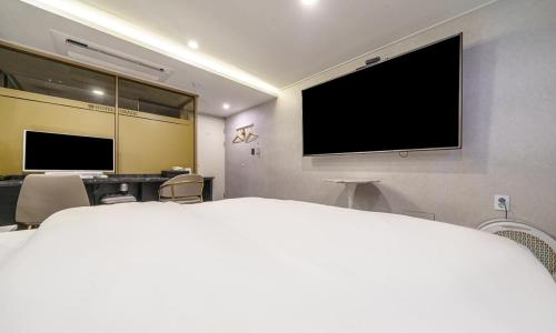 a bedroom with a bed and a flat screen tv at Paju Geumchon Grache in Paju