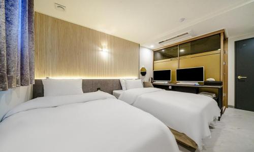 a hotel room with two beds and a desk at Paju Geumchon Grache in Paju