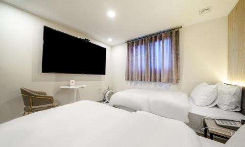 a hotel room with a bed and a flat screen tv at Paju Geumchon Grache in Paju