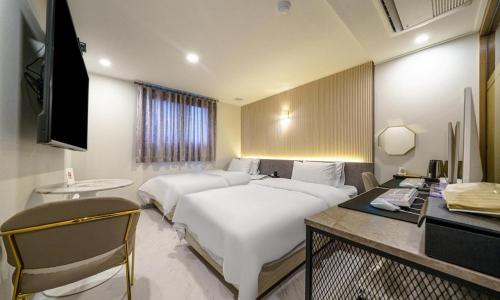 坡州市にあるPaju Geumchon Gracheのベッド2台とデスクが備わるホテルルームです。