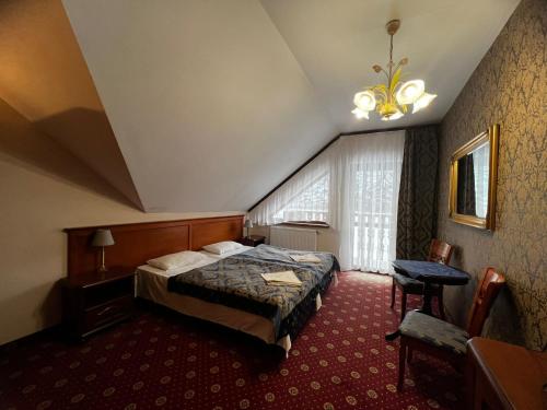 ストロニエ・シロンスキエにあるHotelik Orańskiのベッドと窓が備わるホテルルーム