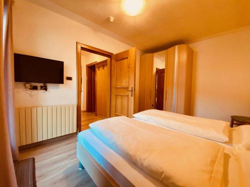 a bedroom with two beds and a flat screen tv at Apartments Residence Montana in Rasun di Sopra
