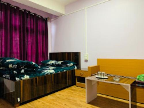 een kamer met twee bedden en een tafel erin bij Hotel Cozi Inn Bomdila in Bomdila