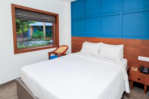 a bedroom with a large white bed and a window at Hudson - A Resort Hotel in Sriperumbudur