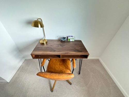 a table with a lamp and a chair with a desk at New 4 Bedroom Home with Ocean and Gorgeous Mountain Views in the gated community of Mauna Olu in Waianae