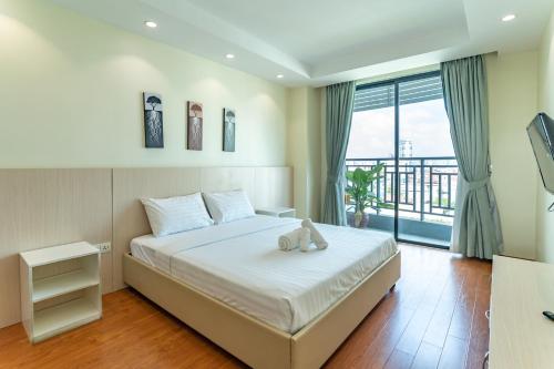 a bedroom with a bed with a teddy bear on it at ANINA Office & Serviced Apartments in Phnom Penh