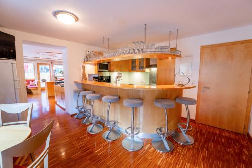a kitchen with a island with bar stools at Hotel Garni Krumbach in Damuls