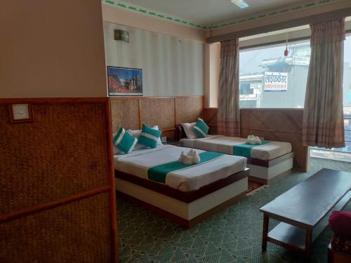 um quarto de hotel com duas camas e uma janela em Pokhara Hotel Deep Sagar em Pokhara