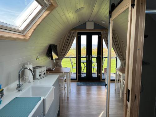a kitchen with a vaulted ceiling with a window at Warren Farm Retreat - Pod 1, Pod 2, and The Lodge by SSW in Cardiff